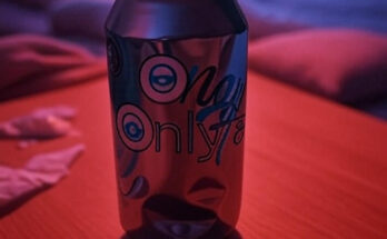 OnlyFans crumpled can on a bedside table bathed in reddish neon-light.